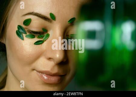 Nahaufnahme`s Gesicht einer jungen Frau mit Buchsbaumblättern. Spa und Wellness Konzept Vorlage Banner für Design. Werbung für kosmetische Produkte Stockfoto